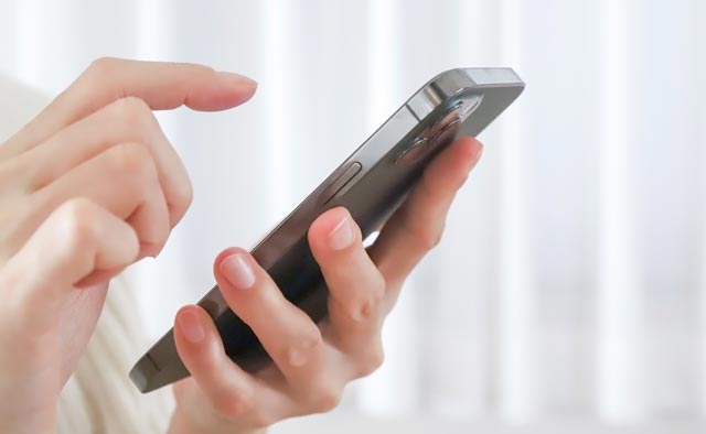 家族葬の海老名市葬儀社に電話でお問合せしようとしている人の手元。